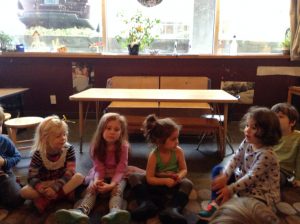 children sitting on the ground, discussing their thoughts about holidays and santa